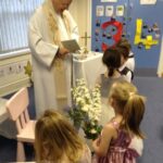 pupils lining up in front of priest to receive communion