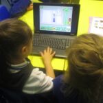pupils sitting in front of a laptop looking at the screen