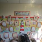 school display board with drawing of a lighthouse and letters completed by pupils