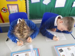 pupils with heads down working at their desks doing school work