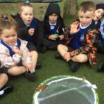 young pupils sitting in a circle watching butterflies being released