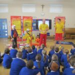 pupils sitting on the floor and listening to visitors talking about water safety